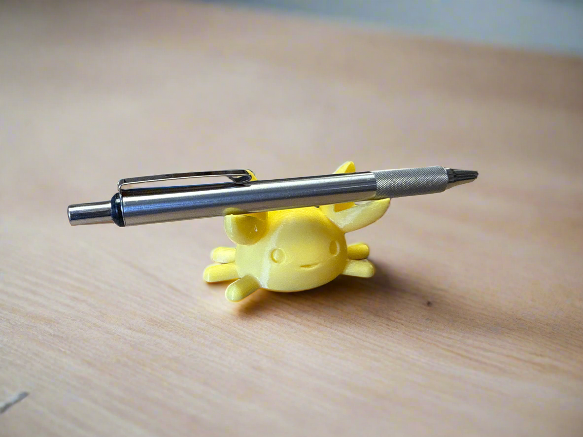 A cute crab pen holder resting on a desk, proudly holding a fountain pen in its claws