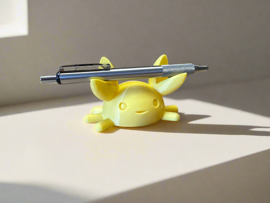 A cute crab pen holder resting on a desk, proudly holding a fountain pen in its claws