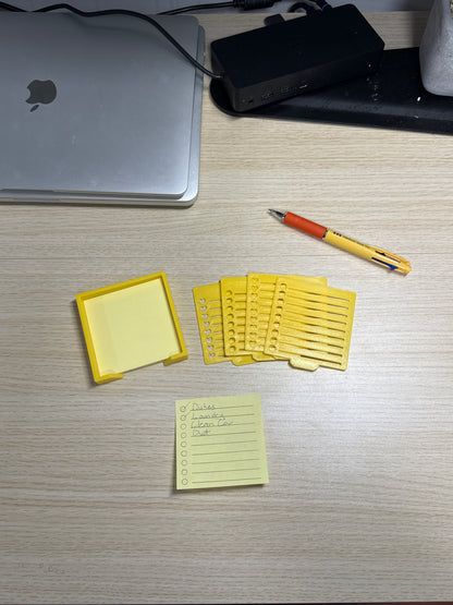 A collection of sticky notes, a pen, and a biodegradable plastic holder with stencils, displayed on a wooden surface.