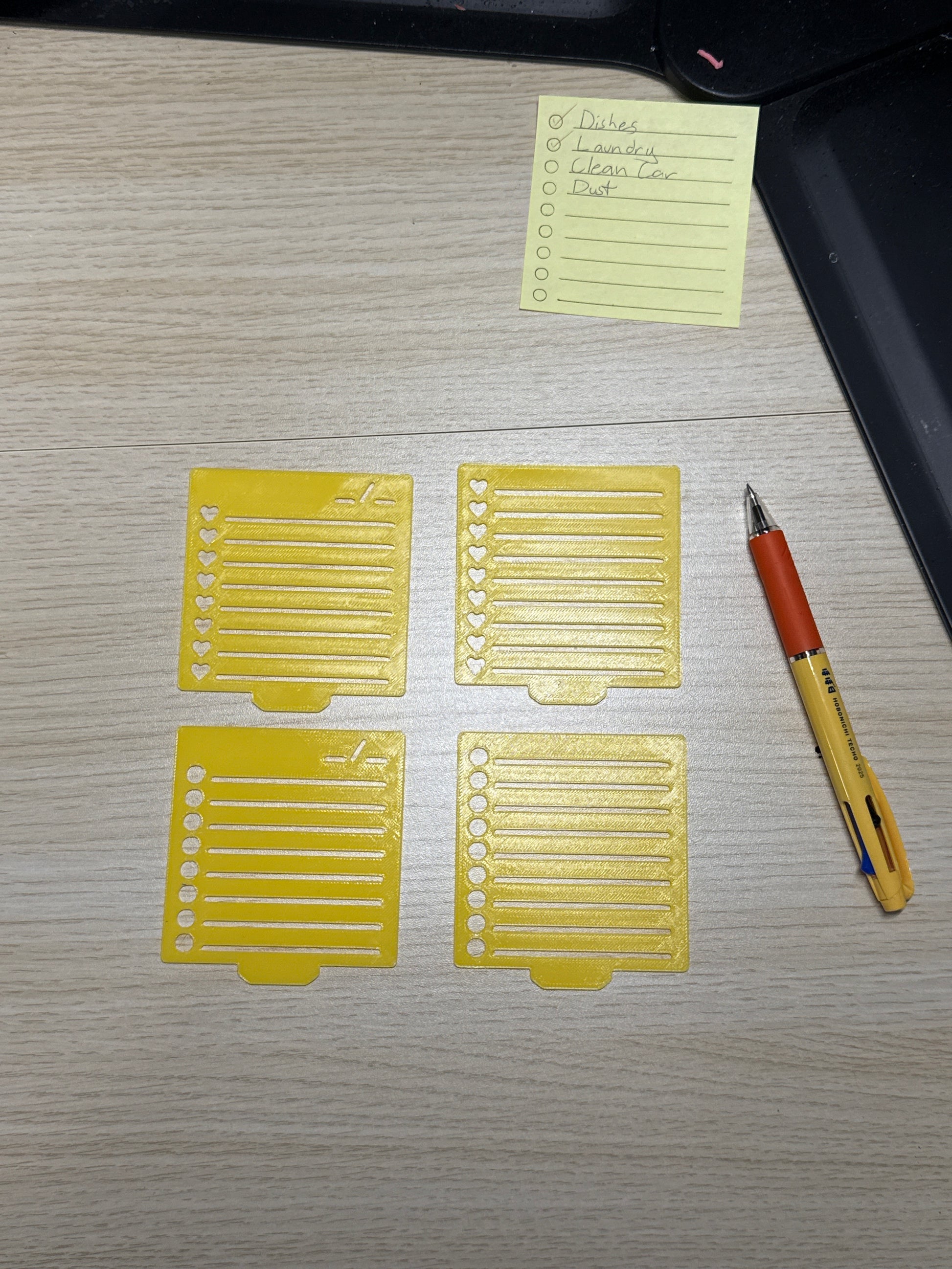 4 stencils laid out with a sticky note and a pen.