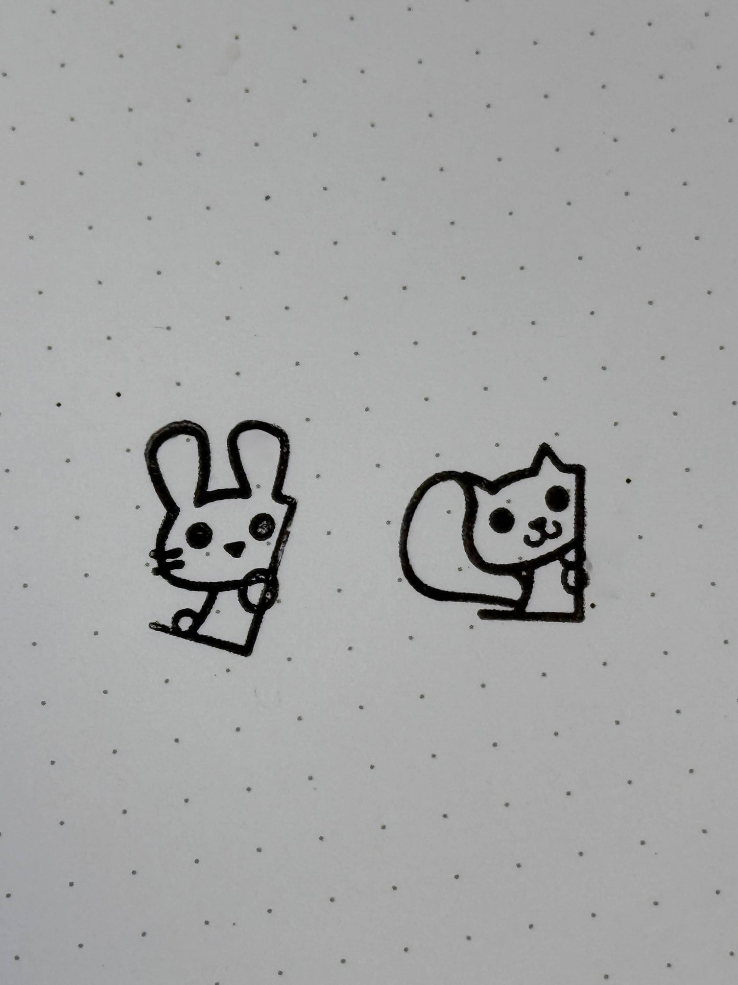 A stamp of a bunny and of a squirrel on dot paper.